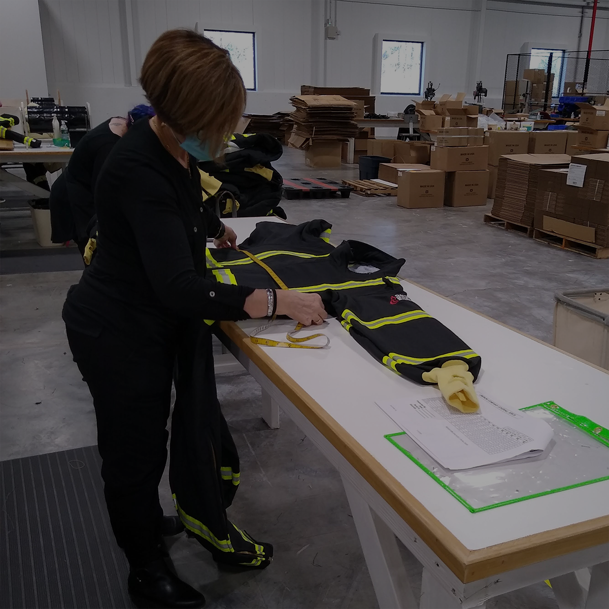worker checking measurements of a gas extraction suit before it gets packed up