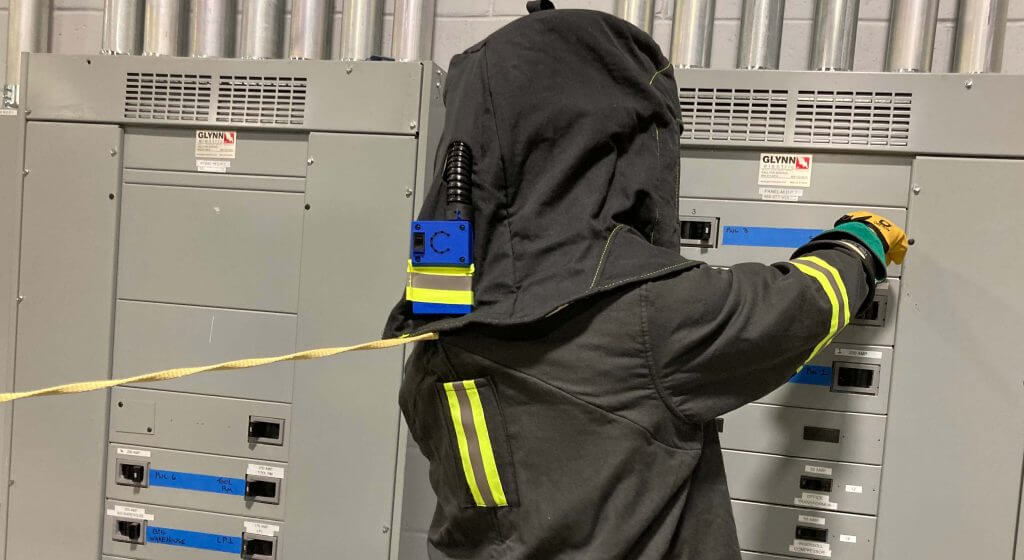 Worker braces to pull coworker to safety with the Escape Strap in case of an arc flash