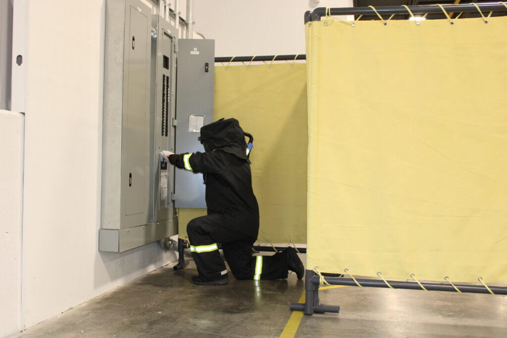 The Blanket Cube set up to protect the nearby area as a worker works at a panel.